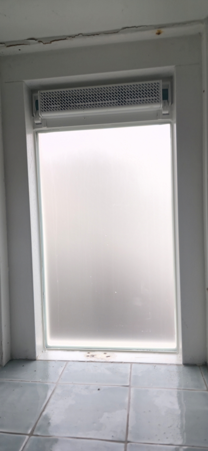 Matglas raam met een ventilatierooster erboven
